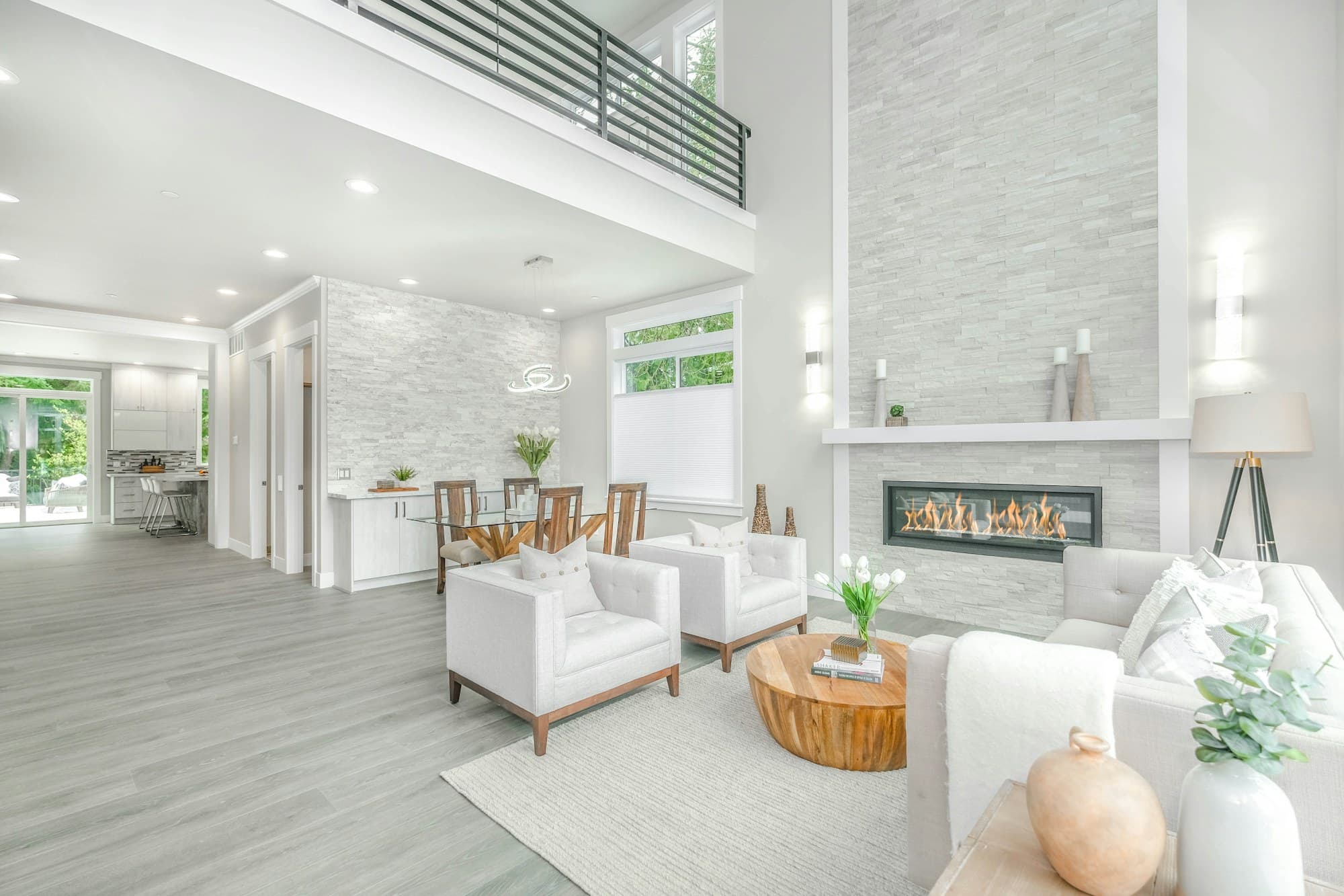 A bright, double-height living room with a stone fireplace
