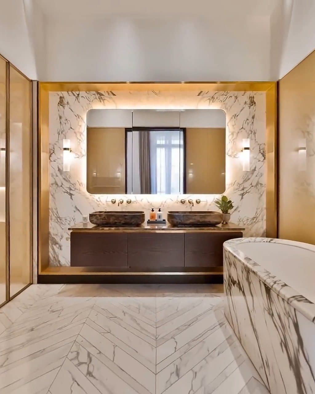A marble bathroom with twin basins and a freestanding bath